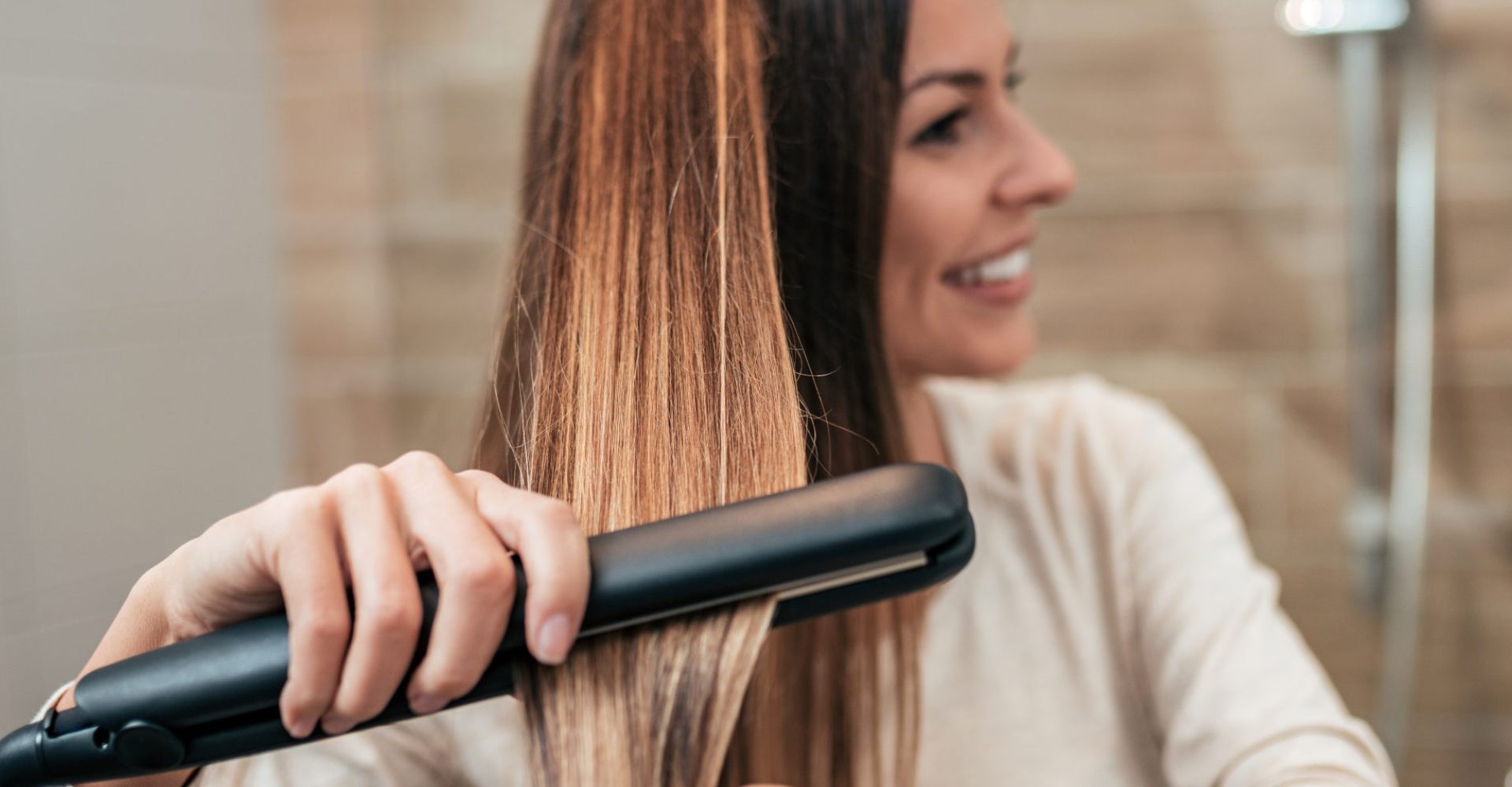 immagine di una ragazza con capelli lisci che si sta piastrando i capelli