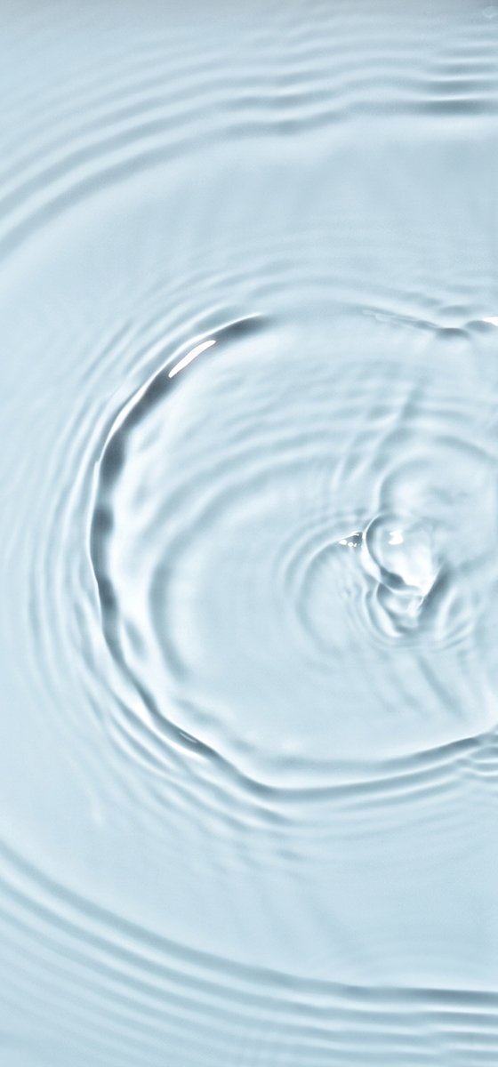 Immagine di una goccia d'acqua aperta su sfondo azzurro.