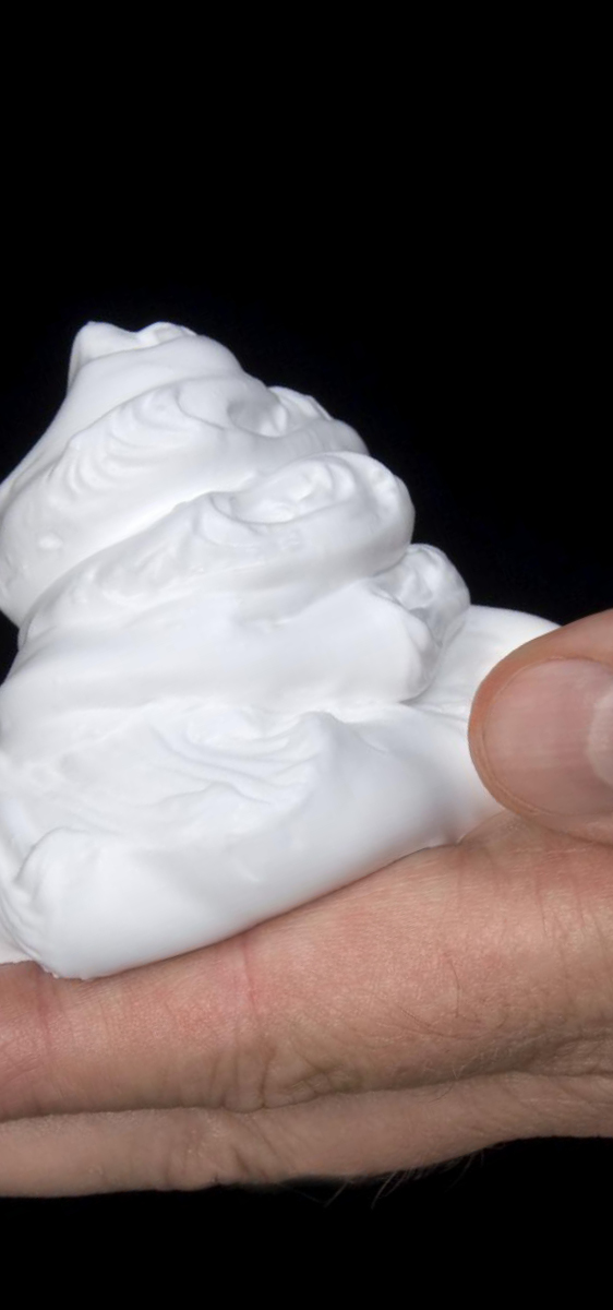 immagine di una mano di un uomo su sfondo nero, con sopra una noce di mousse bianca.